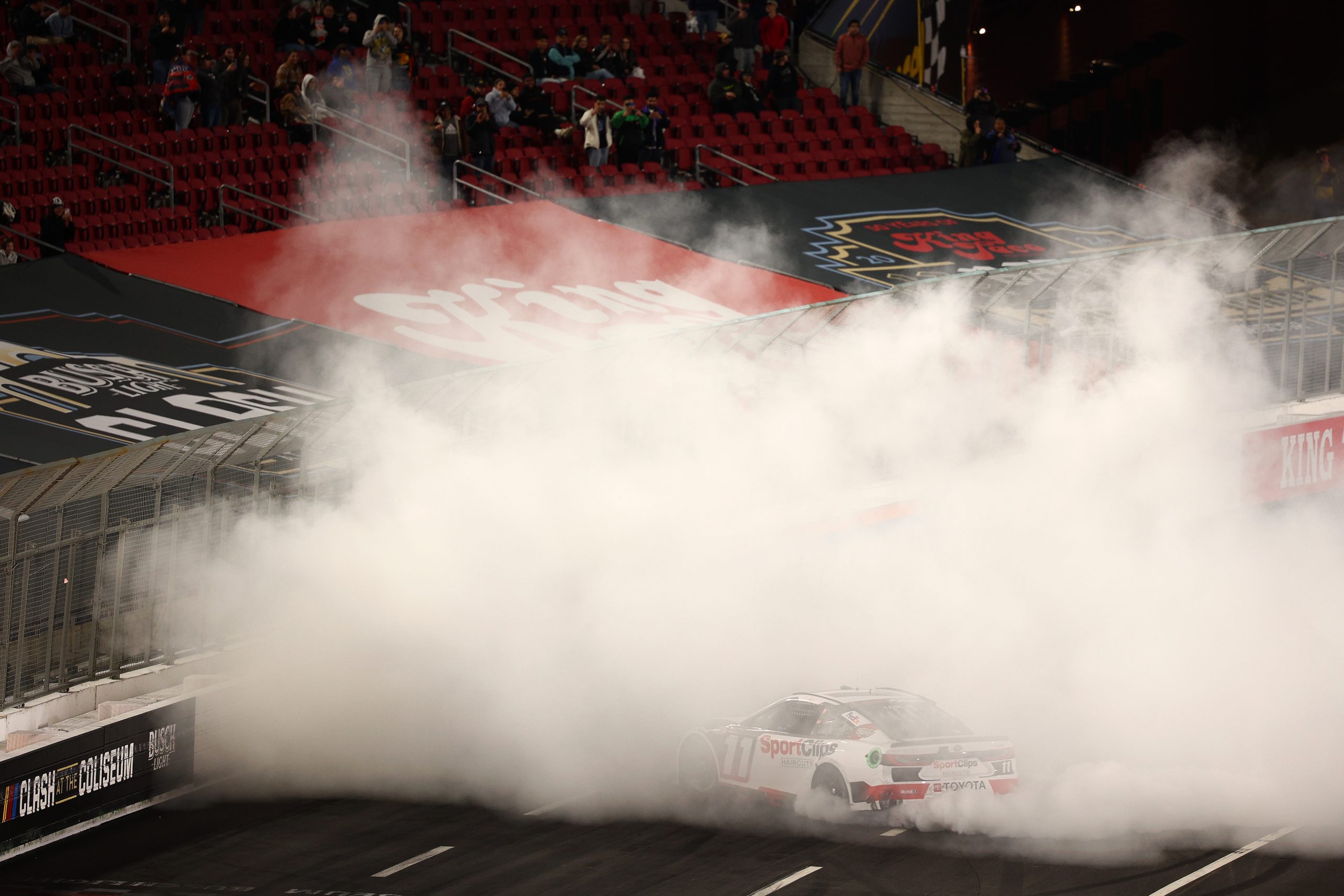 Denny Hamlin, driver of the #11 Sport Clips Haircuts Toyota, celebrates with a burnout after winning the NASCAR Cup Series Busch Light Clash at The Coliseum at Los Angeles Memorial Coliseum on February 03, 2024 in Los Angeles, California.