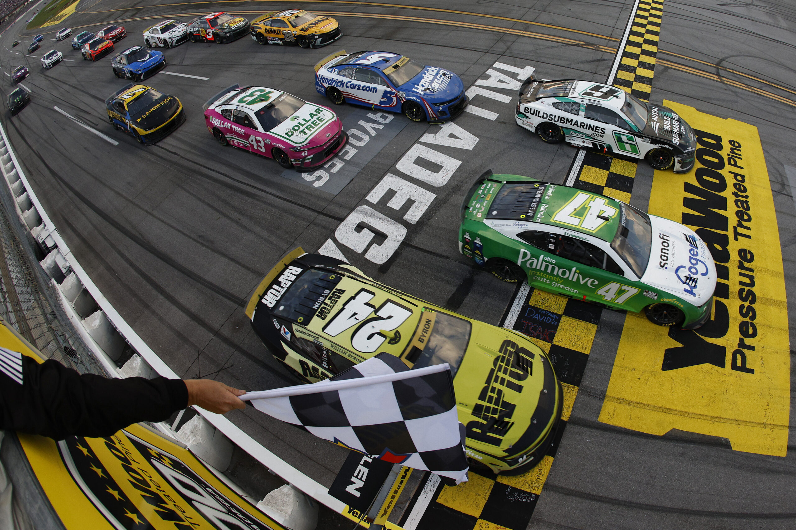 TALLADEGA, ALABAMA - OCTOBER 06: Ricky Stenhouse Jr., driver of the #47 Kroger Health/Palmolive Chevrolet, takes the checkered flag ahead of Brad Keselowski, driver of the #6 BuildSubmarines.com Ford, and William Byron, driver of the #24 RaptorTough.com Chevrolet, to win the NASCAR Cup Series YellaWood 500 at Talladega Superspeedway on October 06, 2024 in Talladega, Alabama.