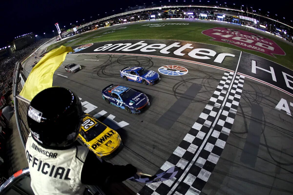 HAMPTON, GEORGIA - FEBRUARY 23: Christopher Bell, driver of the #20 DEWALT Toyota, takes the checkered flag under caution to win ahead of Carson Hocevar, driver of the #77 Delaware Life Chevrolet, and Kyle Larson, driver of the #5 HendirickCars.com Chevrolet, in the NASCAR Cup Series Ambetter Health 400 at Atlanta Motor Speedway on February 23, 2025 in Hampton, Georgia. (Photo by Chris Graythen/Getty Images)