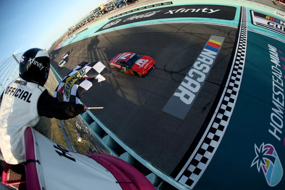HOMESTEAD, FLORIDA - MARCH 22: Justin Allgaier, driver of the #7 BRANDT/TradeMark Nitrogen Chevrolet, takes the checkered flag to win the NASCAR Xfinity Series Hard Rock Bet 300 at Homestead-Miami Speedway on March 22, 2025 in Homestead, Florida. (Photo by Chris Graythen/Getty Images)