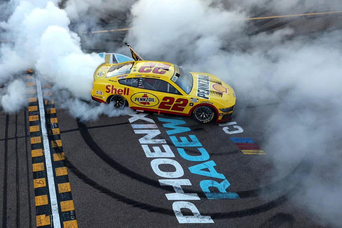 AVONDALE, ARIZONA - NOVEMBER 10: Joey Logano, driver of the #22 Shell Pennzoil Ford, celebrates with a burnout after winning the NASCAR Cup Series Championship Race at Phoenix Raceway on November 10, 2024 in Avondale, Arizona. (Photo by Meg Oliphant/Getty Images)