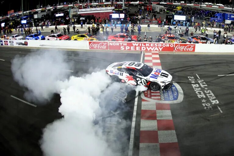 NORTH WILKESBORO, NORTH CAROLINA - MAY 18: Christopher Bell, driver of the #20 Mobil 1 Toyota, celebrates with a burnout after winning the NASCAR Cup Series All-Star Race at North Wilkesboro Speedway on May 18, 2025 in North Wilkesboro, North Carolina. (Photo by David Jensen/Getty Images)