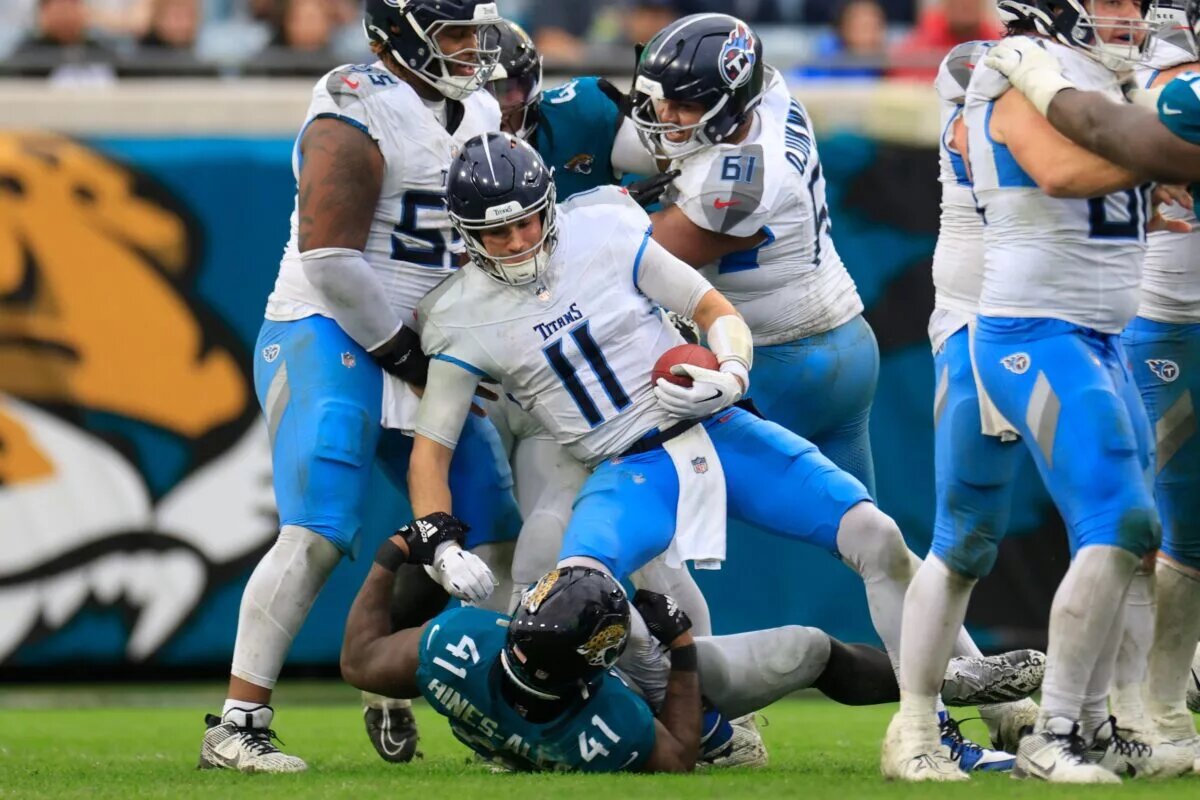 Jaguars defensive end Josh Hines-Allen tackling Titans quarterback Mason Rudolph