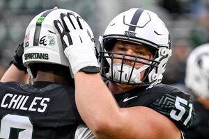 MSU Center Matt Gulbin and quarterback Aidan Chiles embrace