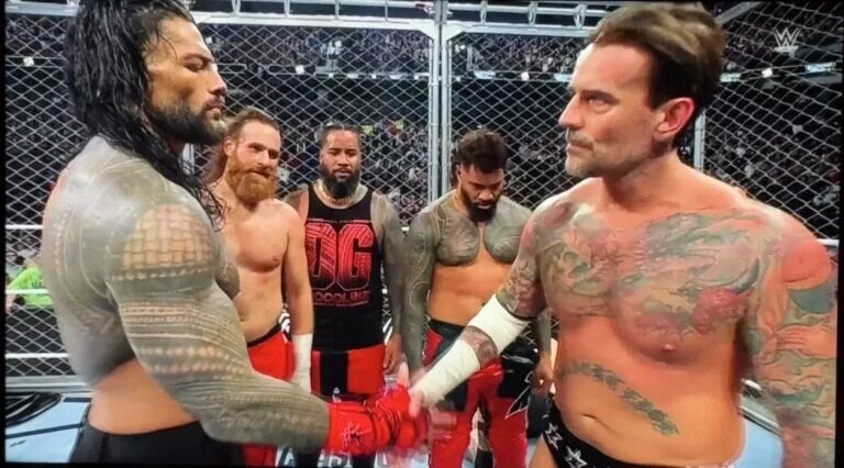 A photo of Roman Reigns and CM Punk shaking with The Usos and Sami Zayn at WWE Survivor Series 2024: WarGames.
