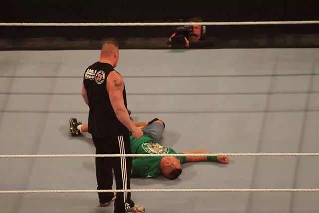 Image of Brock Lesnar standing over John Cena