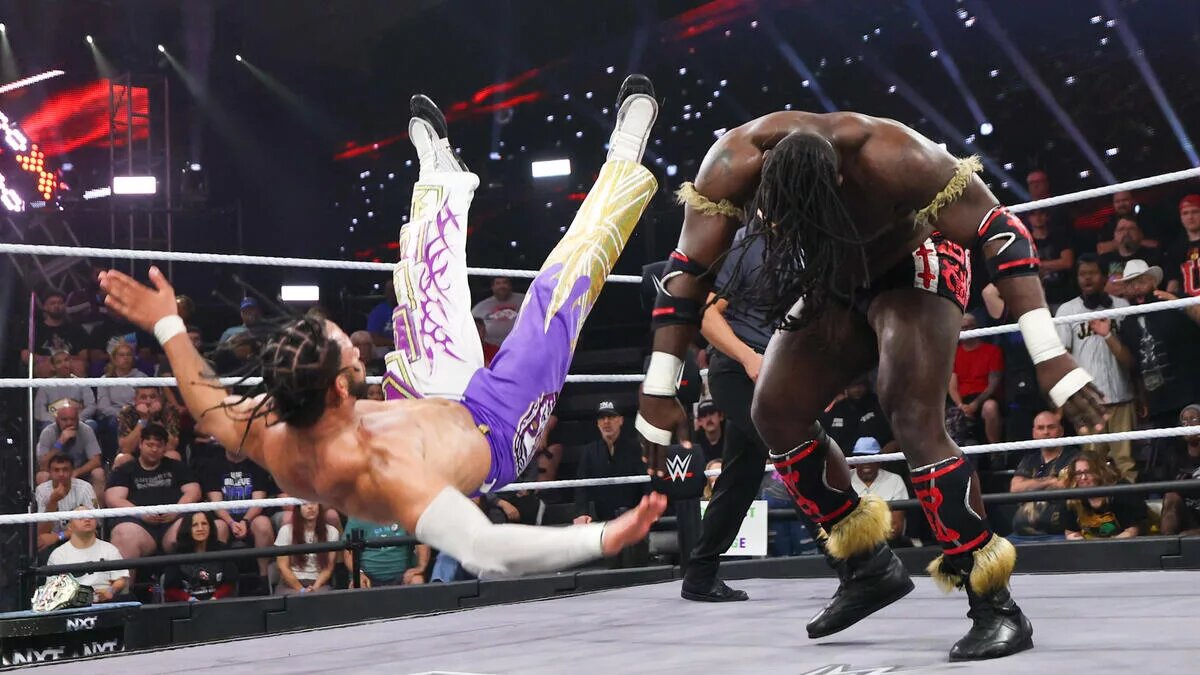 A graphic of Oba Femi and Leon Slater in their NXT New Year's Evil match