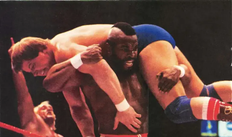 A photo of Mr. T hoisting up Roddy Piper at WWE WrestleMania 1 looking to slam him.