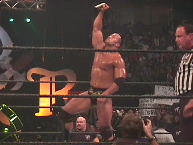 A photo of The Rock during the Attitude Era at the King of the Ring event holding up the WWE/F Championship.